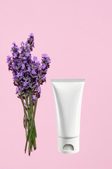 White empty bottle and lavender bouquet on a pink background. The concept of natural, organic cosmetics. Vertical image.