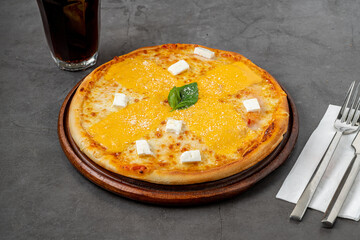 Italian pizza with four cheeses and lots of mozzarella on a cutting board