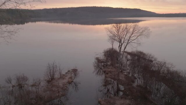 Aerial shot over a stream flowing into Monson Pond at Sunrise 
