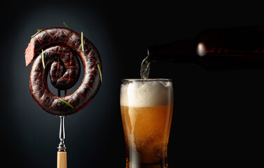 Black pudding or blood sausage with rosemary and a glass of beer.