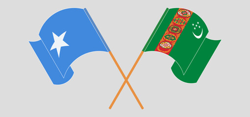 Crossed and waving flags of Somalia and Turkmenistan