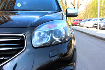 Obraz na płótnie Canvas Modern SUV headlight with headlight washer. Car headlight. Headlight of black SUV.