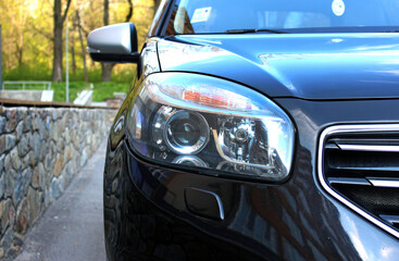 Modern SUV headlight with headlight washer. Car headlight.  Headlight of black SUV.