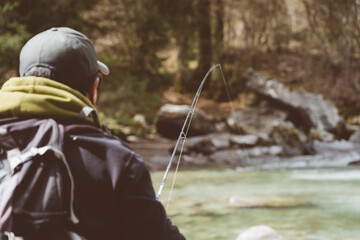 Pescatore in azione durante una battuta di pesca nelle acque di un torrente montano in Trentino...