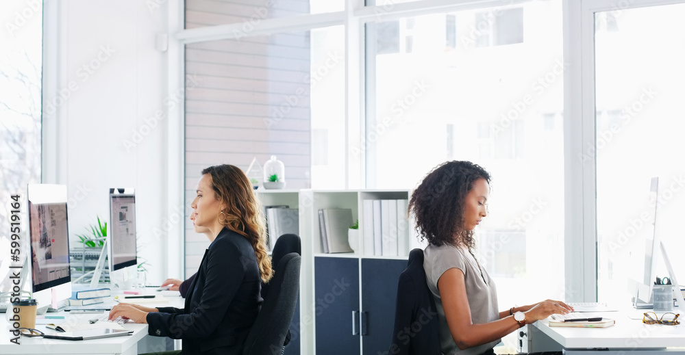 Poster working individually to achieve a common goal. a group of young businesswomen using their computers 