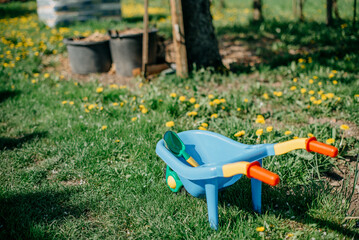Obraz na płótnie Canvas Children's plastic gardening trolley as a toy for children for outdoor activities in the garden.
