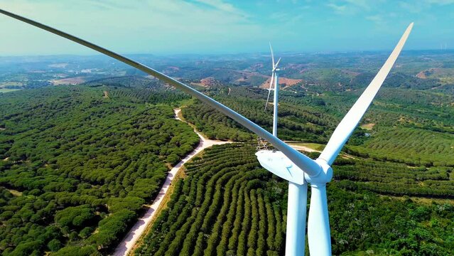 Zoom out of camera from a propeller of the windmill in the forest - aerial, Clean and Renewable Energy 