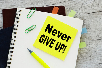 Never give up written on yellow sticker