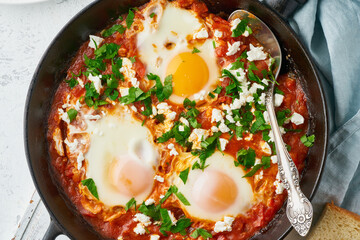 Shakshouka, eggs poached in sauce of tomatoes, olive oil. Mediterranean cousine. - obrazy, fototapety, plakaty