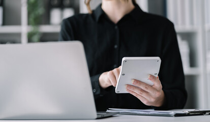 Women are using calculators to calculate office income.
