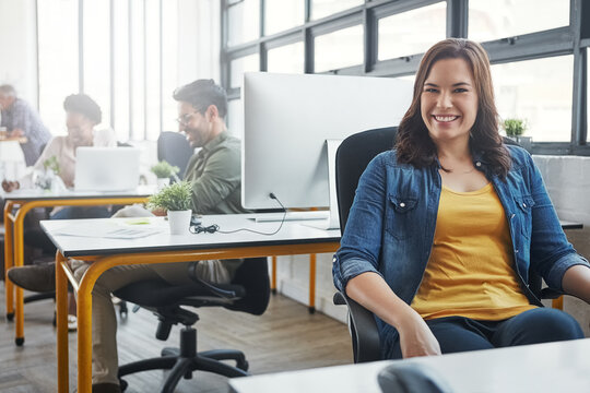 Find a career related to your passion. a young designer in an office with her colleagues in the background.
