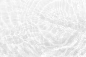 White water with ripples on the surface. Defocus blurred transparent white colored clear calm water surface texture with splashes and bubbles. Water waves with shining pattern texture background.