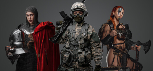 Studio shot of female soldier holding rifle with ancient amazon and knight woman. - obrazy, fototapety, plakaty