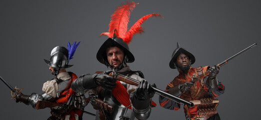 Portrait of conquistadors with steel armor and plumed helemt holding flintlock guns.