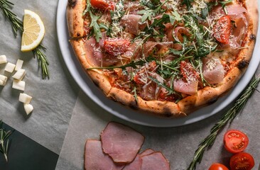 Tasty pizza with  prosciutto and  arugula 