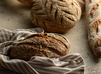 freshly baked crusty bread lying on a kitchen towel