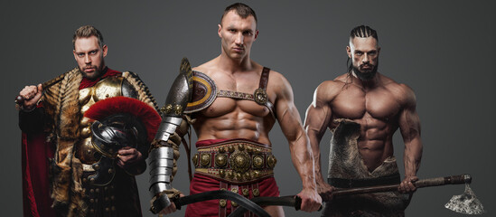 Fototapeta na wymiar Shot of shirtless gladiator and muscular viking with greek soldier against grey background.