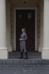 Outdoor portrait of woman in grey fitted midi dress in the city, fall fashion collection