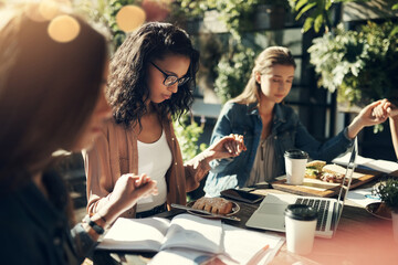 Giving thanks for the food. a group of creative employees holding hands and praying before breakfast outdoors.