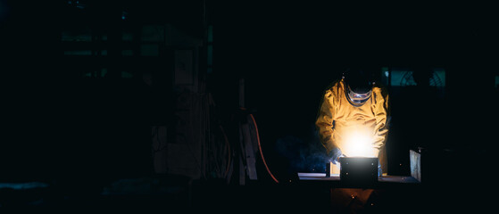 Industrial worker welds and cutting a metal at the factory. Worker is wheel grinding on steel...
