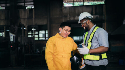 Engineer are working in the factory. Worker helping to repair and inspect the machine's readiness.