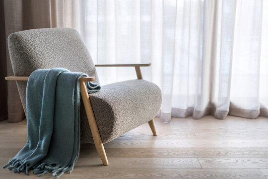 Plaid throw over wooden armrest on armchair