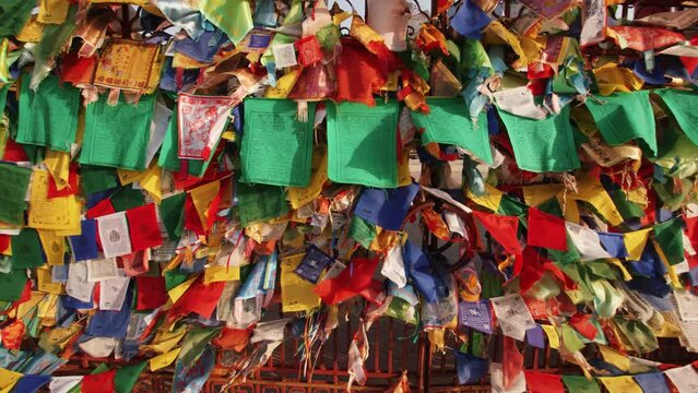 Small colored flags with buddhist symbols and mantras are tied to the fence of the temple