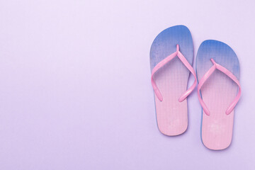 Bright flip flops on color background, top view