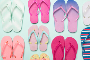 Many bright flip flops on color background, top view