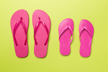 Many bright flip flops on color background, top view
