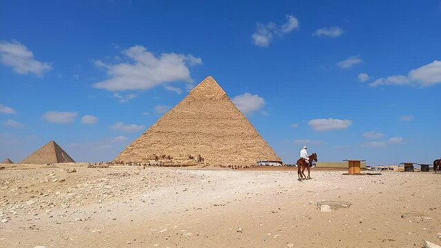 Time lapse con nuvole veloci che scorrono sulla Piramide di Cheope e un dromedario in movimento