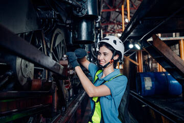 Fototapeta na wymiar Portrait of female engineer working and looking camera in industrial factory. Women in industry concept.