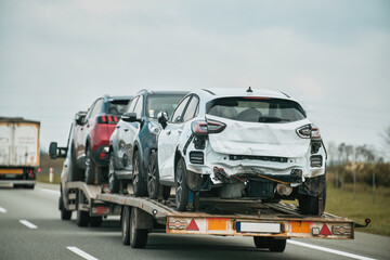 Tow truck with broken car on country road. Tow truck transporting car on the highway. Car service transportation concept.