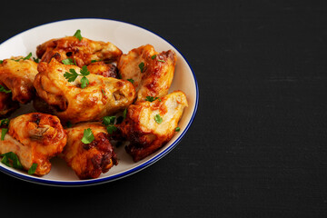 Homemade Grilled Chicken Wings with Parsley on a Plate, side view. Copy space.