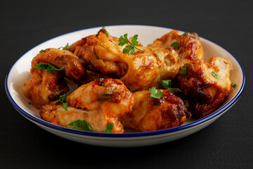 Homemade Grilled Chicken Wings with Parsley on a Plate, side view.