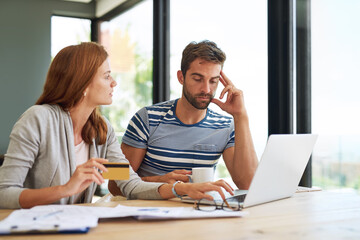 Financial planning can sometimes be a strain. a young couple working on their household budget and paying bills online.