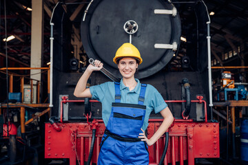 Portrait of woman engineer standing and looking camera in train factory. Maintenance cycle concept.