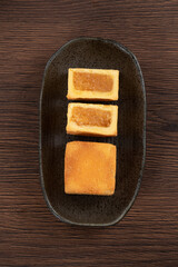 Delicious pineapple cake pastry in a plate on wooden table background with tea.