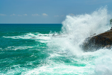 Fototapeta premium Splashes of waves crashing against the rocks