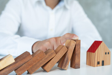 insurance with hands protect domino. Businessman hands stop dominoes falling in house crisis. business risk control and planning and strategies to run prevent insurance businesses.
