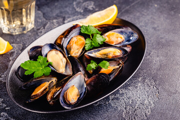 Delicious seafood mussels with sauce and parsley.