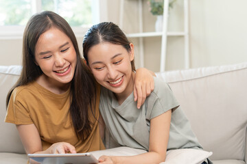 LGBT group. Good looking lesbian couples smile use tablet at home on holiday. Asian young couple hug each other happily, lover in love, bisexualities, homosexuality, liberty, expression, happy life