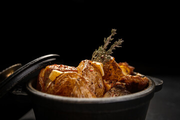 Fried potatoes with garlic and spices in a small cast-iron pot