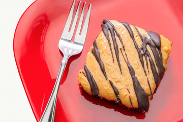 Peanut butter fudge brownie on a red plate with a fork