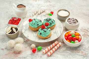 front view colorful candies with cream cakes on white background biscuit sweet cake cookie
