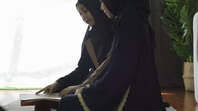 An Asian Muslim women reciting Salah or Salat al-Fatiha passage of the Qur'an, in a single act of sujud called a sajdah or prostrations at home