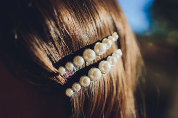 Pearl and filagree hair clasp in beautiful long reddish brown hair - close up.