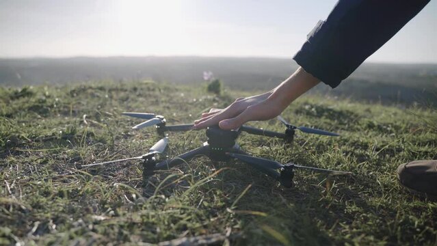 A hand switching on a drone to fly.