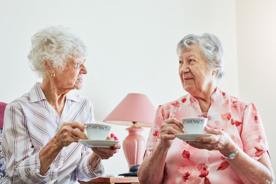 Those catch up sessions are golden. two happy elderly women having tea together at home.
