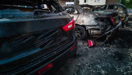 Broken and burned cars in the parking lot, accident or deliberate vandalism. Burnt car....